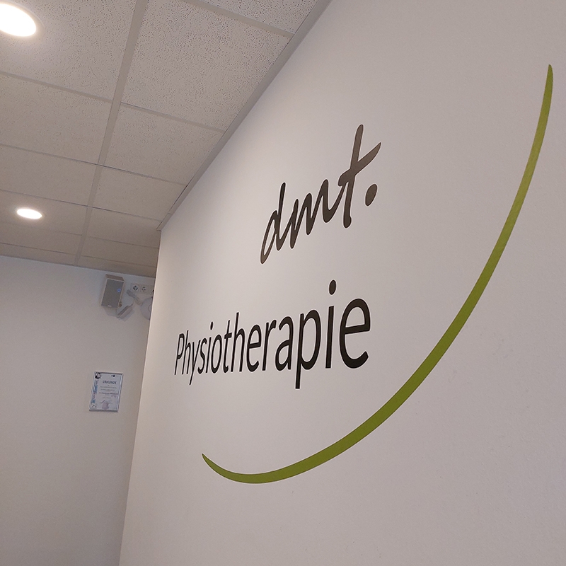Logo von dmt. Physiotherapie an der Wand in der Praxis.