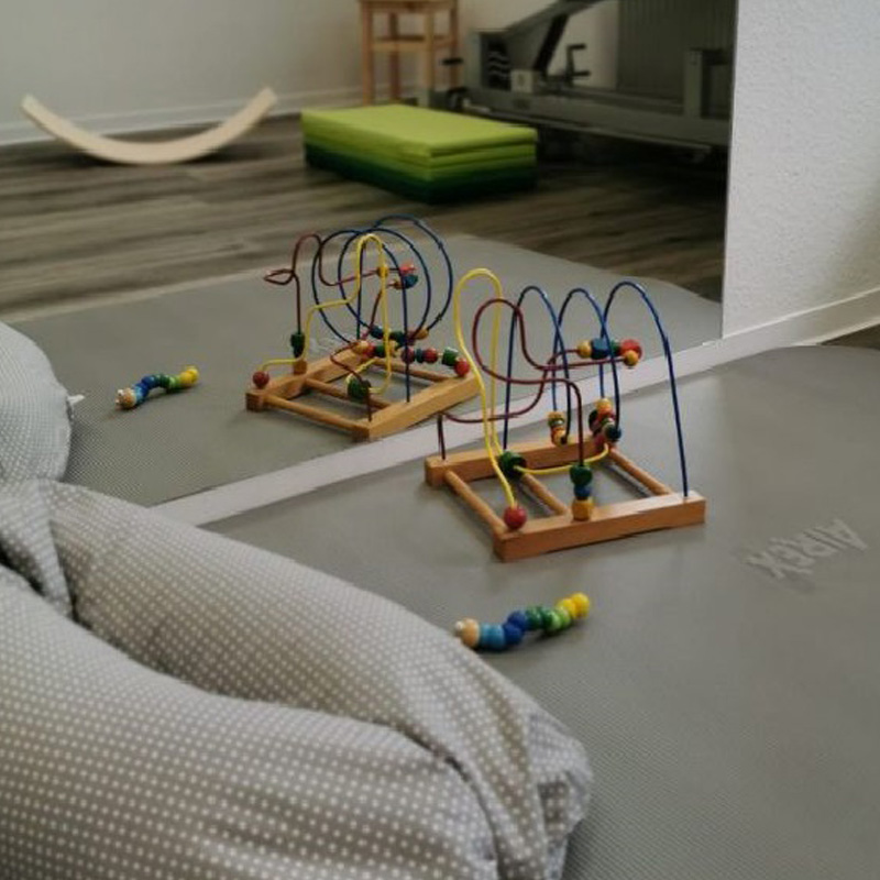 Physiotherapie-Praxis für Kinder. Motorische Spielsachen auf einer Übungsmatte.