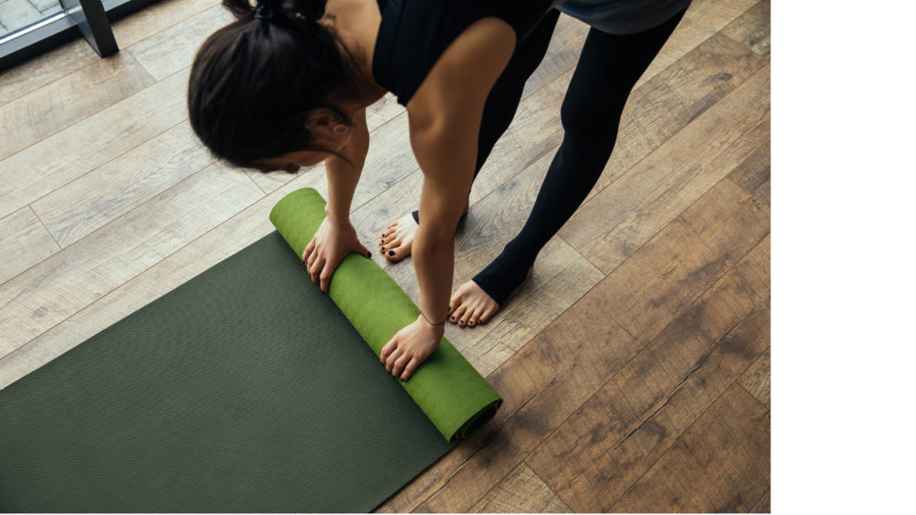 Klangyoga verbindet die Vorteile von Meditation und Yoga. Eine Frau die einer Yogamatte ausbreitet.
