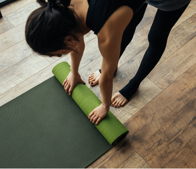 Klangyoga verbindet die Vorteile von Meditation und Yoga. Eine Frau die einer Yogamatte ausbreitet.