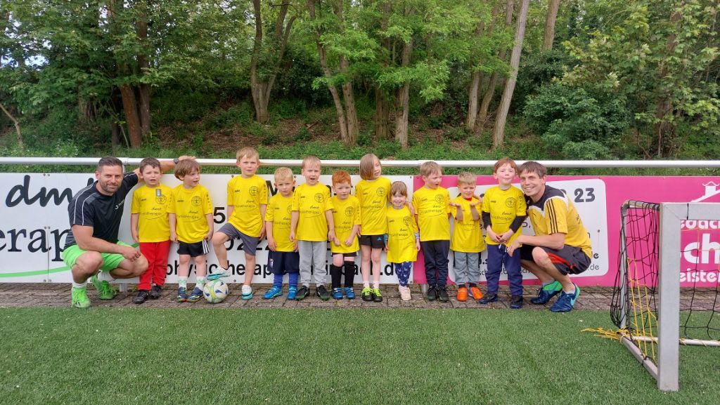 Auf dem Bild ist die Bambini Mannschaft des FC Flerzheim mit Dennis zu sehen. Sie tragen ihre neuen Trikots mit dem Logo der dmt. Physiotherapie.