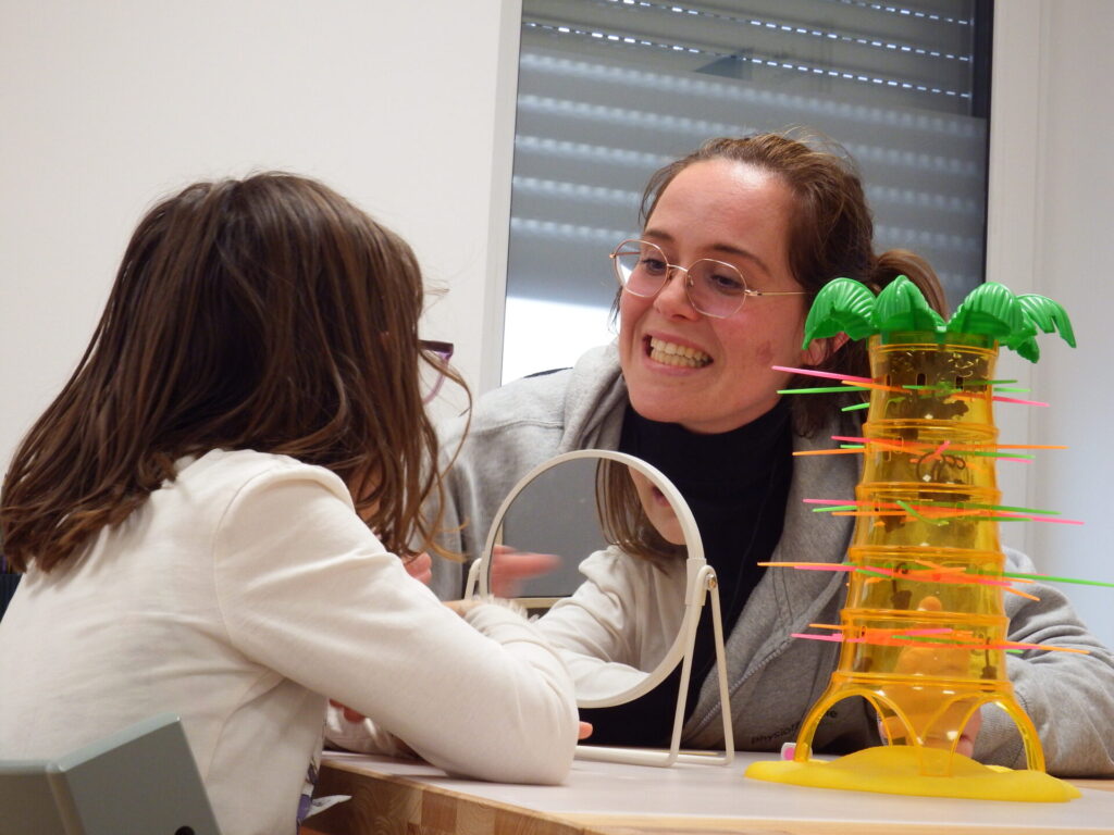 Jessi zeigt ihrer Patienten Übungen mit dem Mund.