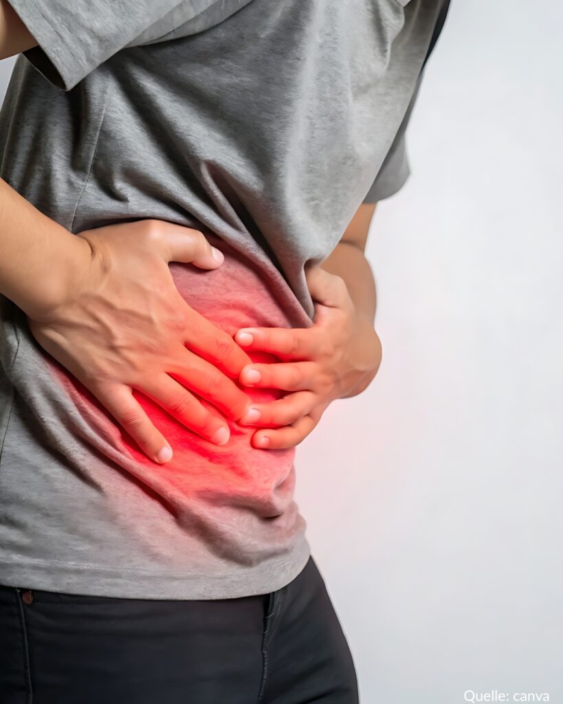 Person greift sich an den schmerzenden Bauch.