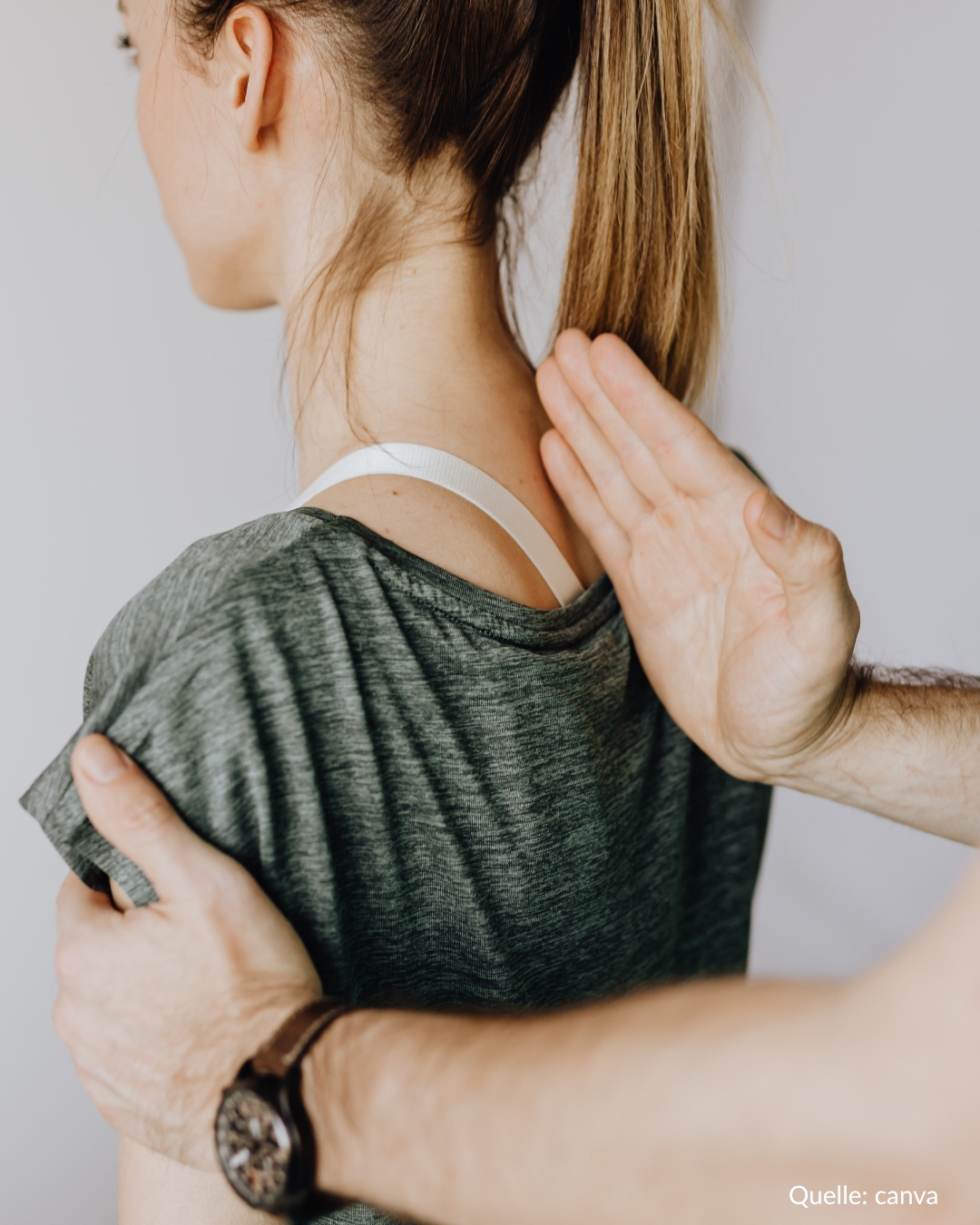 Der Therapeut legt seine Handkante an die Wirbelsäule der Patientin