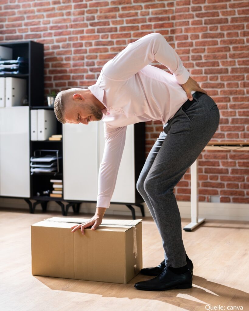 Mann versucht Packet aufzuheben. Hat aber Schmerzen im unteren Rücken.