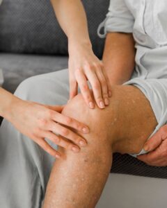 Bild zeigt ein Knie, dass gerade abgetastet wird.