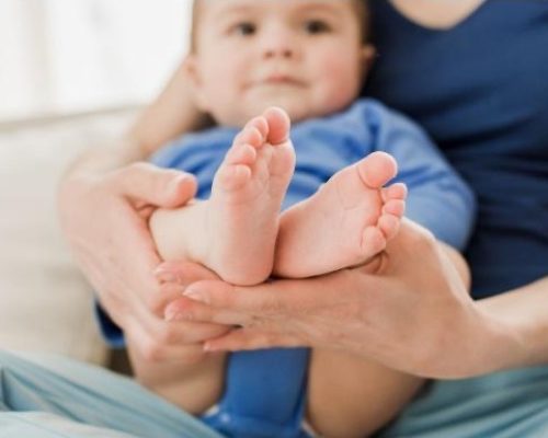 Zukunft-Huber Physiotherapie-Übung mit Kleinkind an den Beinen.